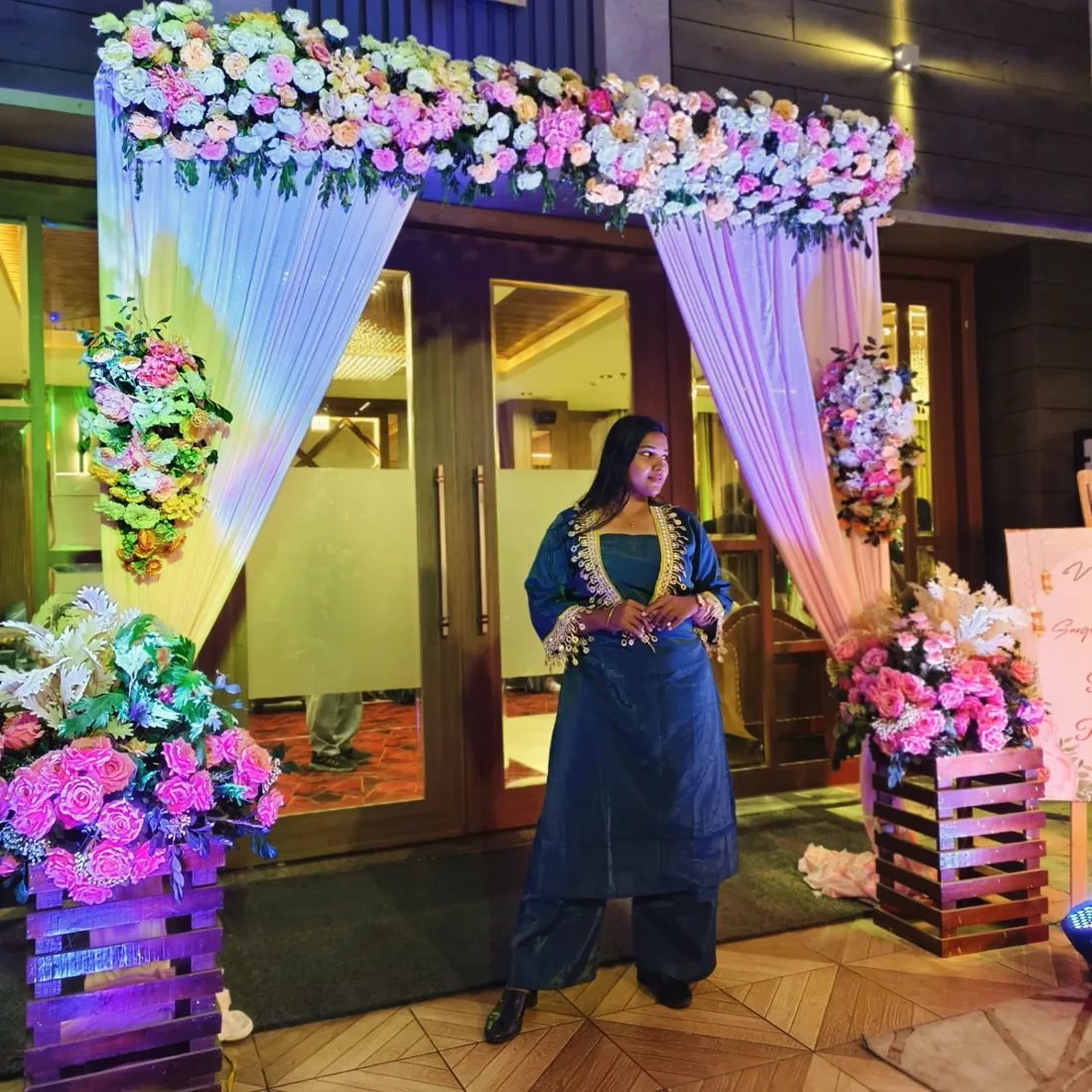At the floral entrance of a reception in teal